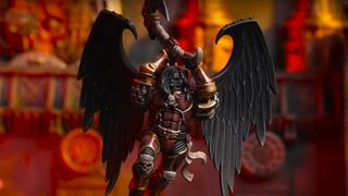 A vampiric Space Marine in red armor and with wings leaps forward, an axe raised above his head